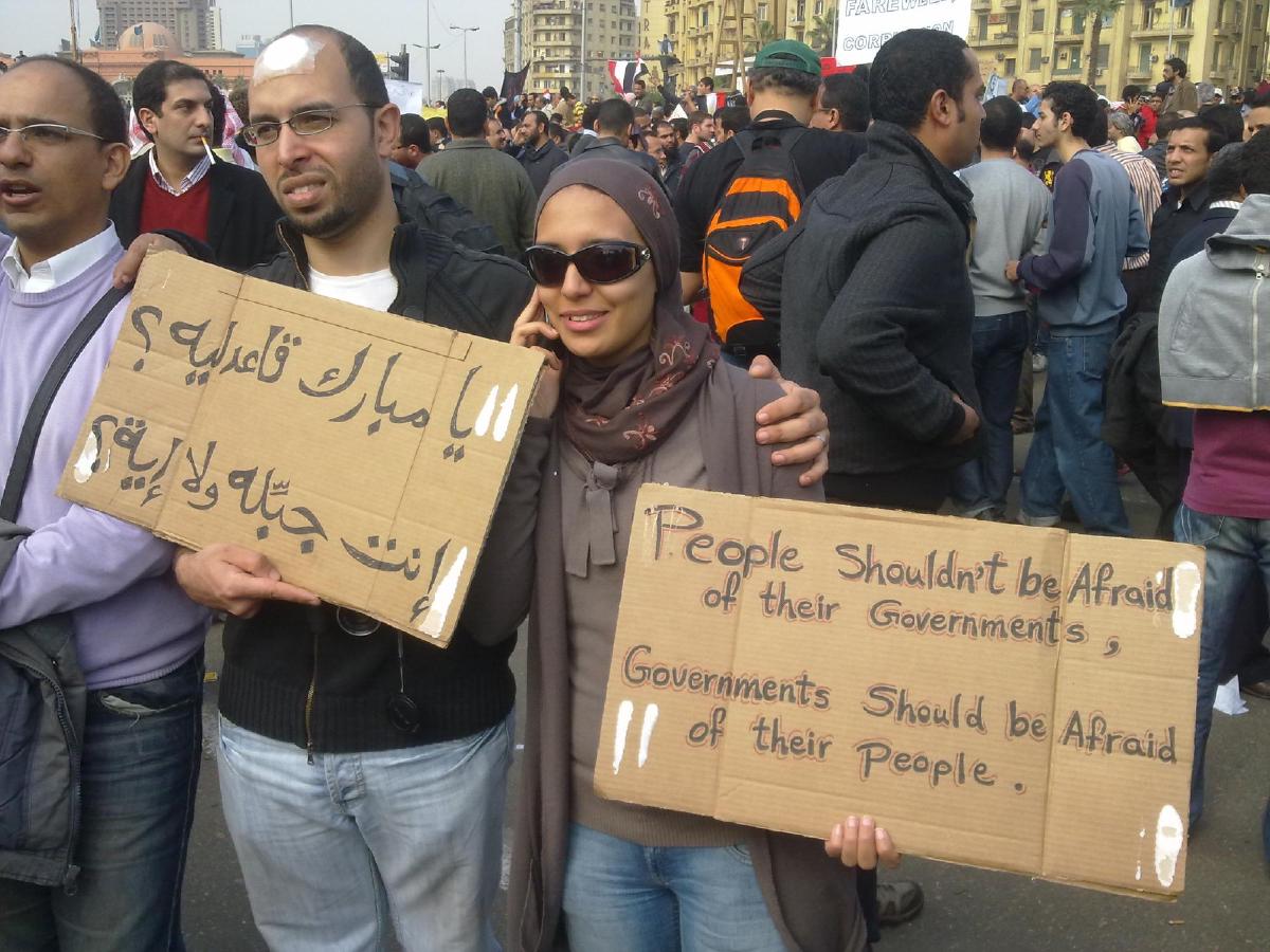A couple of young people carrying cards during the 2011 Egyptian Revolution in El Tahrir Square