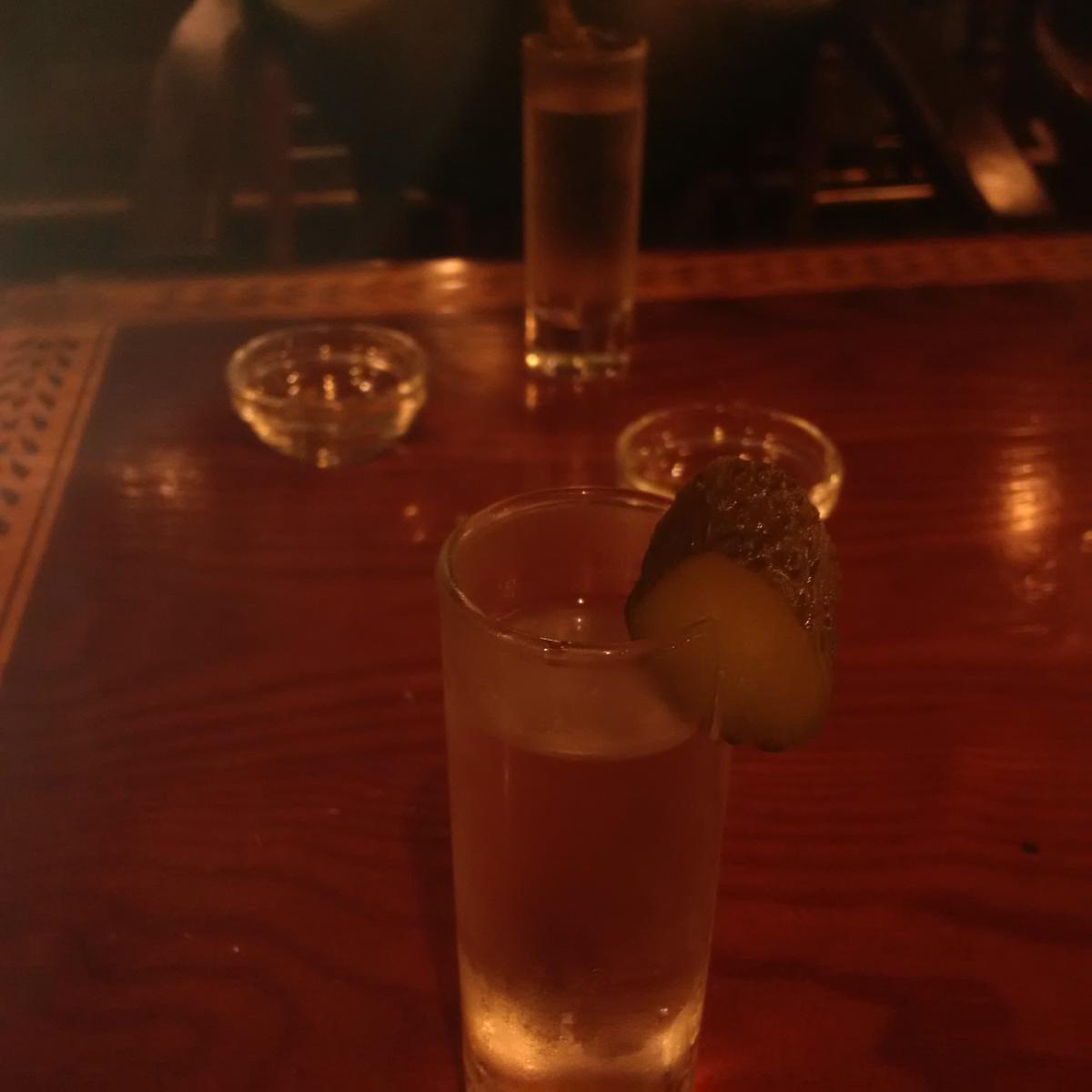 A shot of vodka with a slice of pickle