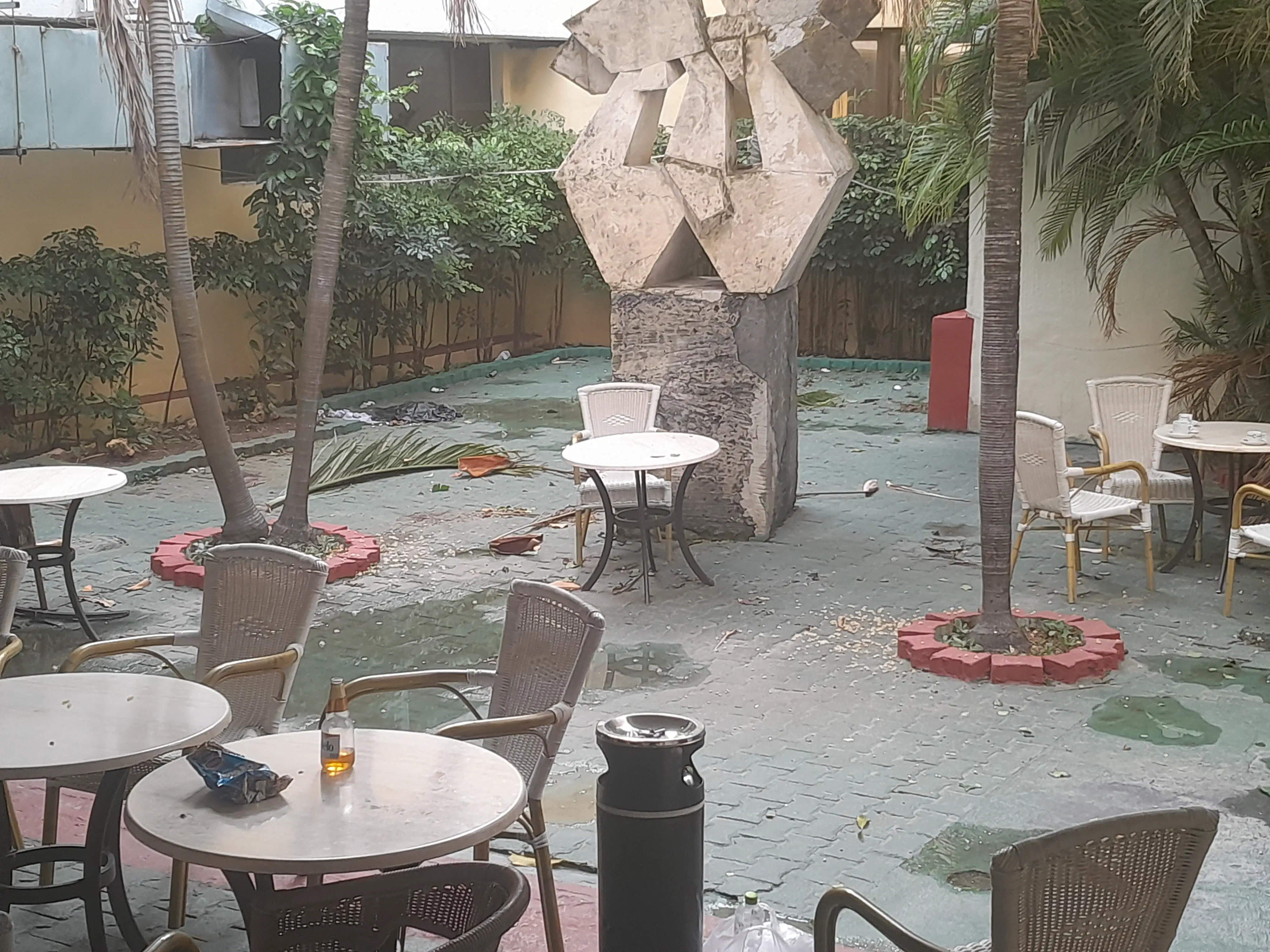 An outdoor seating area covered in pools of water and bits of detritus