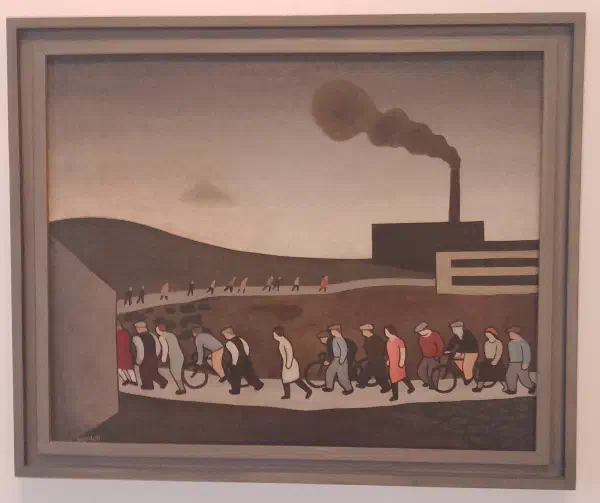 A group of workers walking and cycling towards a distant, smoke-billowing factory