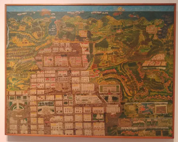 A city viewed from afar, reaching towards the coast