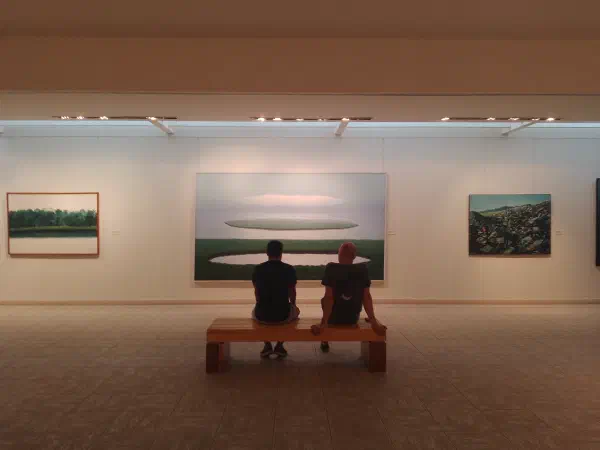 A forest with a circular lake in it alongside the sea with a circular island in it