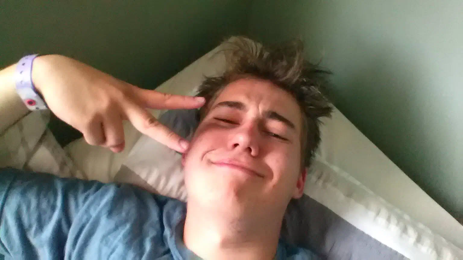 Me in my bed, giving a peace sign