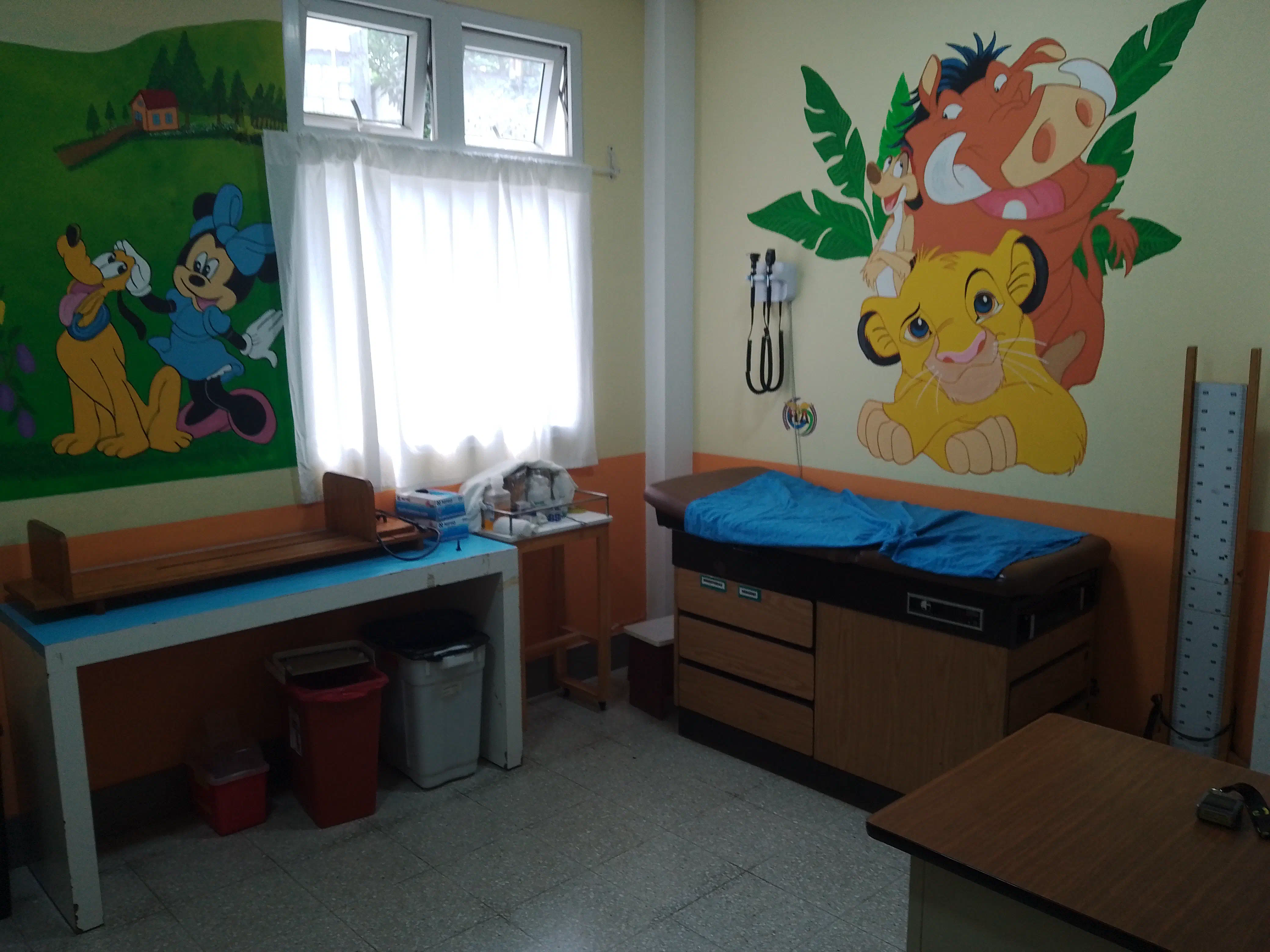 A doctor's office with paintings of cartoon animals on the walls
