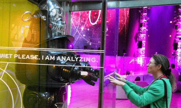 A woman reaching out to a robot