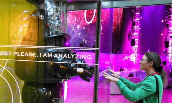 A woman reaching out to a robot