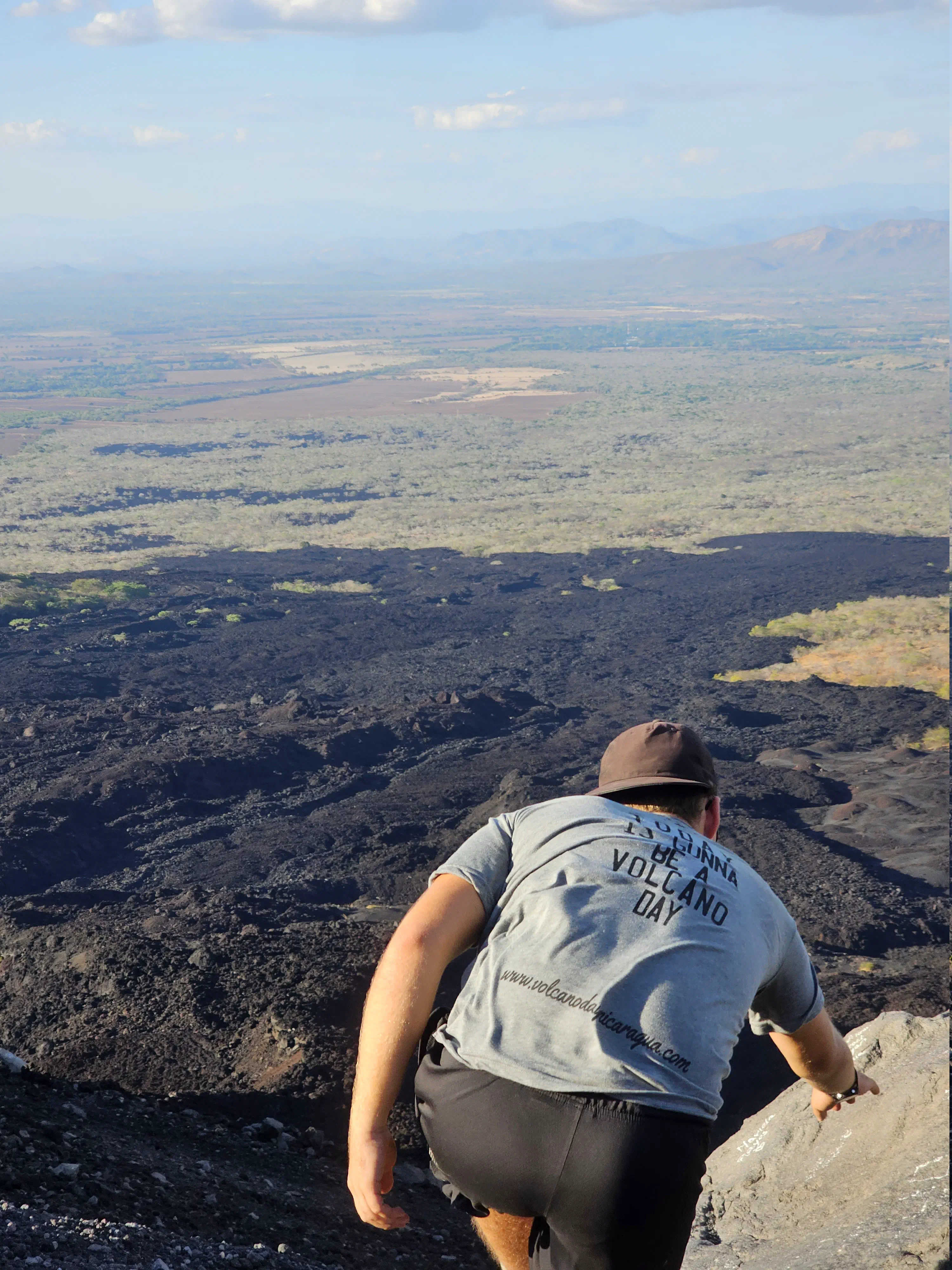 The author, from behind, climbing over a rock into an expansive landscape view