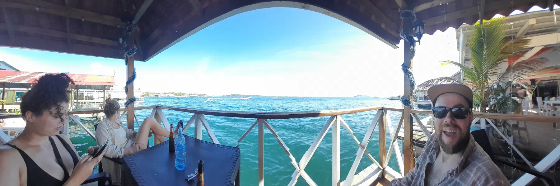 Three people sat around a table, overlooking some water