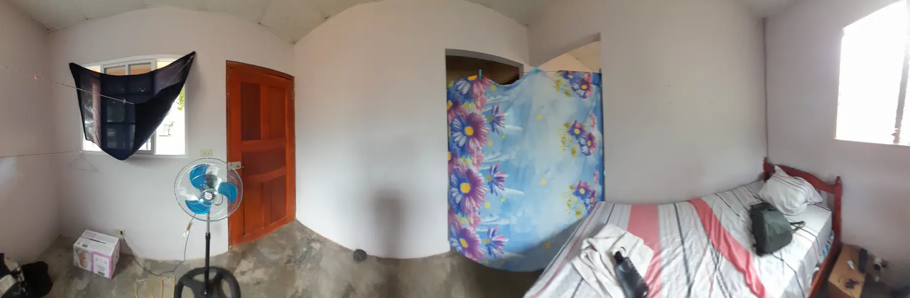 A spartan bedroom, divided from the rest of the building with a towel