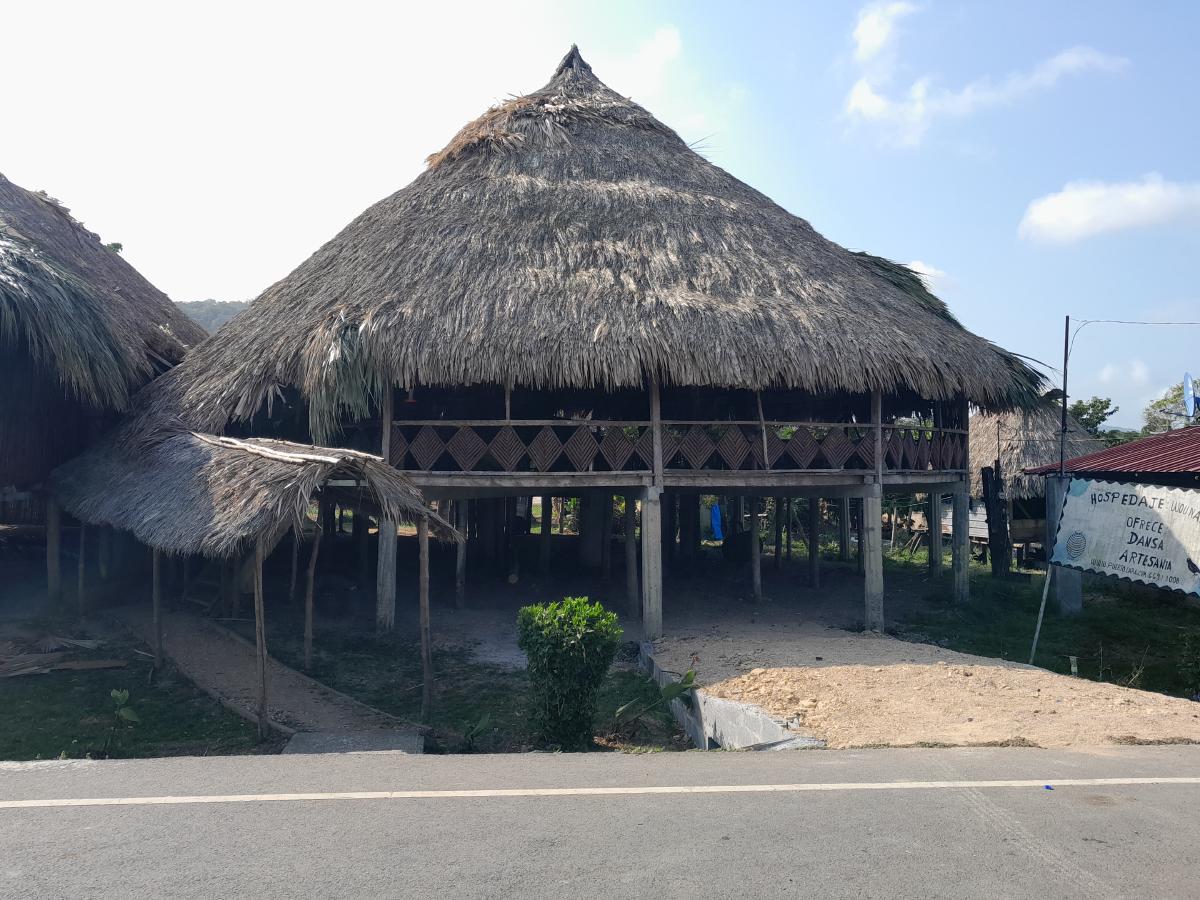 The outside of a large wooden house on stilts