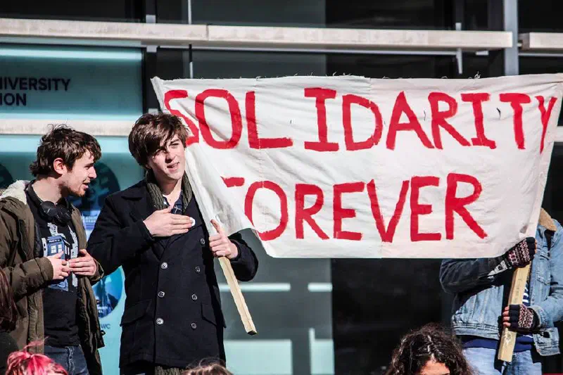 Students at a protest, holding a banner that reads 'Solidarity forever'