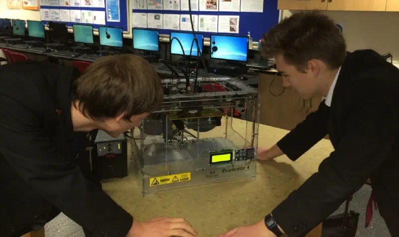 The author looking at a 3D printer