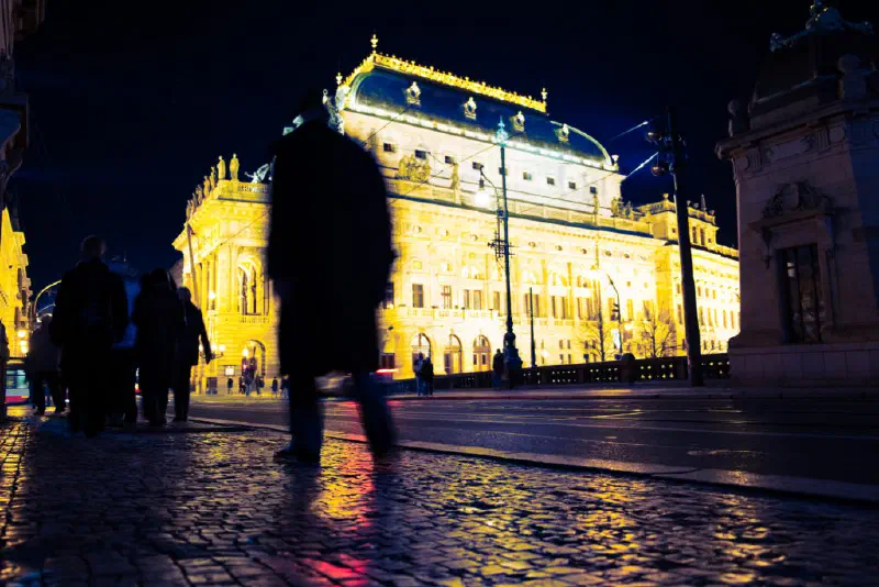 People walking in front of a building at night