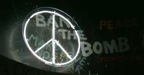 CND symbol in front of graffiti reading 'Ban the bomb'