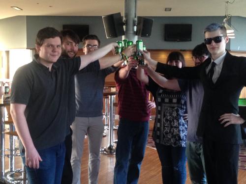 A group of students in a circle toasting towards the centre