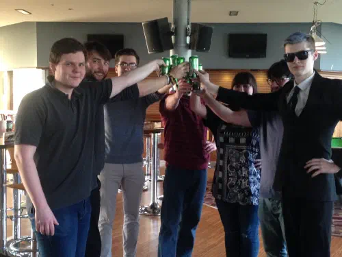 A group of students in a circle toasting towards the centre