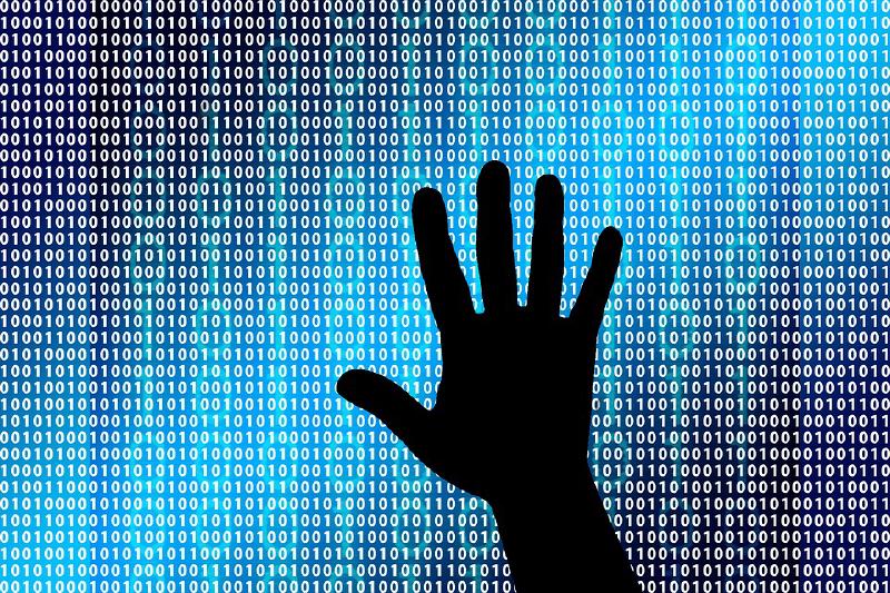 Silhouette of a hand in front of 1s and 0s