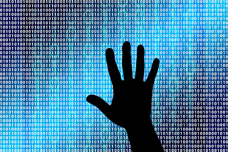 Silhouette of a hand in front of 1s and 0s
