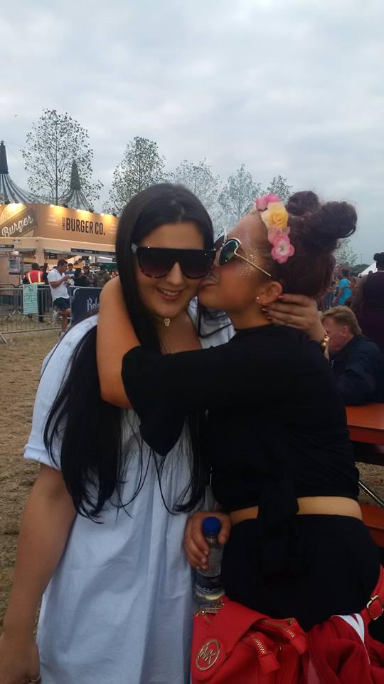 A girl kissing another on the cheek