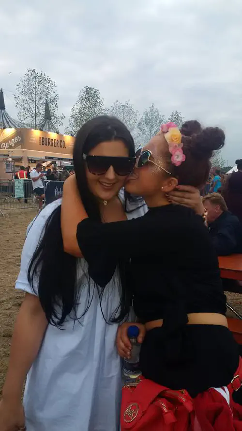 A girl kissing another on the cheek