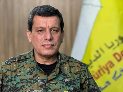 SDF commander Mazloum Abdi before an SDF banner