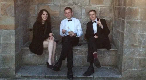 Students in formalwear drinking gin in an alcove