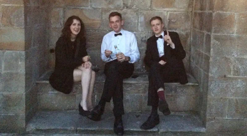 Students in formalwear drinking gin in an alcove