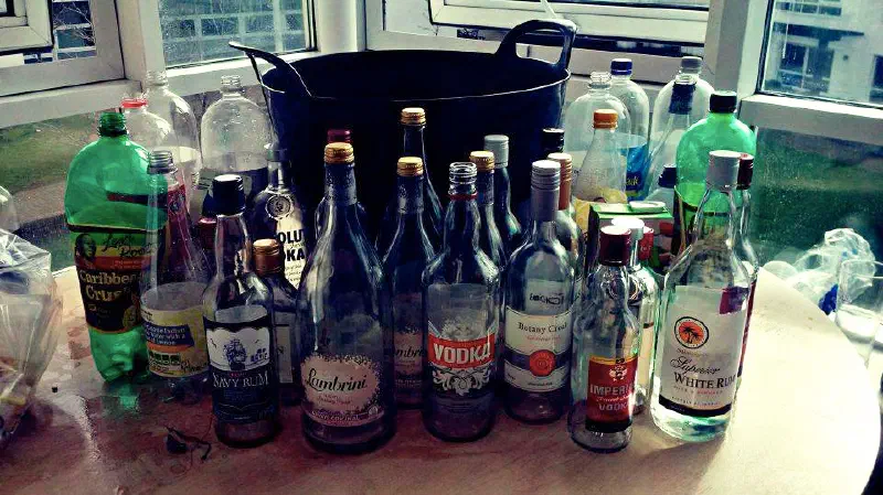 Large bin surrounded by bottles of alcohol